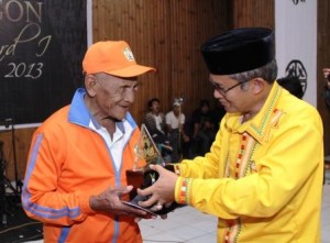 Mukhadi saat menerima anugrah Takengon Award dari Wakil Bupati Aceh Tengah, Drs. H. Khairul Asmara. (Lintas Gayo | Zen Angkasa)