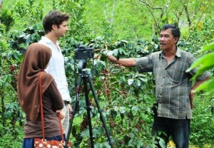 Zaini sedang menjelaskan tentang kopi Arabika kepada 2 orang wisatawan di kebunnya. (Lintas Gayo | Kha A Zaghlul)