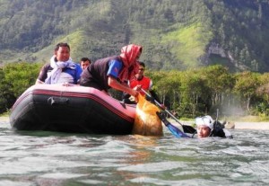 Penyelam wanita, Salawati (paling kanan) mengangkat sekarung sampah dari dasar danau Lut Tawar. (Lintas Gayo | Muna Ardi)