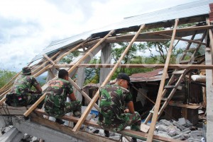 Anggota TNI sedang beristirahat membersihkan rumah warga di Kampung Wih Nongkal Kecamatan Kute Panang. (Foto direkam Minggu, 7 Juli 2013 )