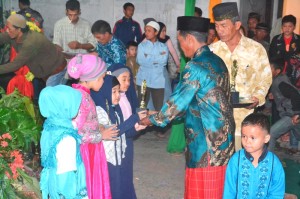 Tgk. Din, guru pengajian di Mersah Takengen Barat saat memberikan tropi. (Dok LG)