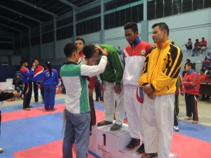 Bardan Sahidi, manager Karate Aceh Tengah, mengalungkan medali kepada atlet karate Aceh, saat dilangsungkan PORA di Aceh Timur (Foto tim PORA)