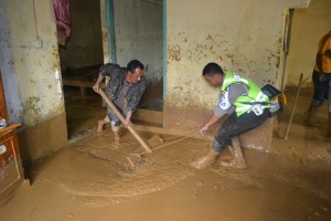 anngota lantas Polres Aceh Tengah, bersama korban longsor Kenawat, membersihkan rumah yang digenanngi lumpur (LG/Dok Lantas)