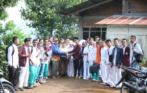 Satria Darmawan bersama sejumlah mahasiswa dan LSM menyerahkan bantuan kepada orang tua Marwansyah yang menderita tumor. Senin (27/10/2014) Foto: IST