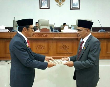 Ketua DPRK Aceh Tengah, Zulkarnain menyerahkan keputusan DPRK tentang penetapan APBK Perubahan 2016 kepada Plt. Bupati Aceh Tengah, Alhudri (Foto : MK)