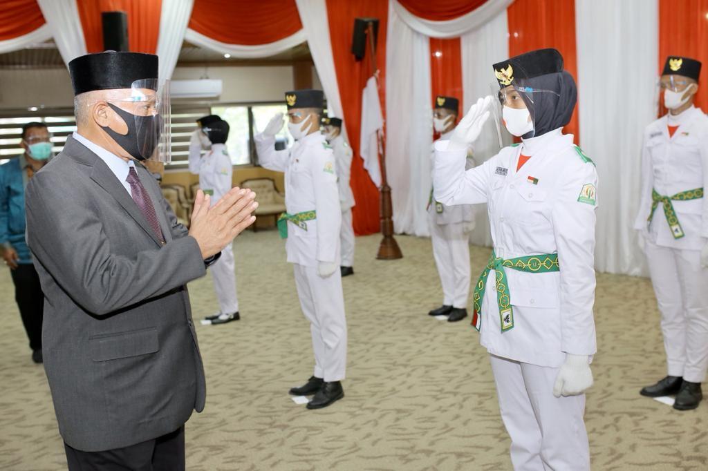 Sekda Aceh, Taqwallah, mengukuhkan pasukan penggerek bendera pada HUT RI ke-75 di Gedung Serbaguna Setda Aceh, Kamis, (13/8/2020). Sebelumnya Sekda Aceh Taqwallah juga mengikuti acara pengukuhan Paskibra Nasional secara daring yang dikukuhkan langsung oleh Presiden Joko Widodo