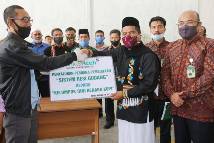 Bupati Bener Meriah Tgk. H. Sarkawi serahkan penyaluran perdana pembiayaan sistem resi gudang Kelompok Tani Kenara Kopi. Kamis, 16/7/2020.