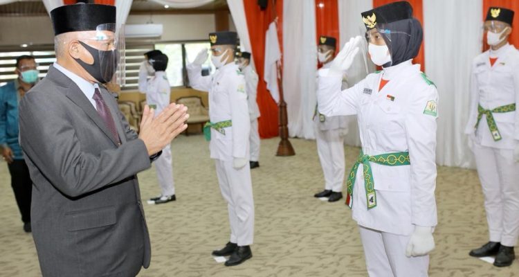 Sekda Aceh, Taqwallah, mengukuhkan pasukan penggerek bendera pada HUT RI ke-75 di Gedung Serbaguna Setda Aceh, Kamis, (13/8/2020). Sebelumnya Sekda Aceh Taqwallah juga mengikuti acara pengukuhan Paskibra Nasional secara daring yang dikukuhkan langsung oleh Presiden Joko Widodo