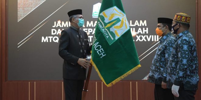 Gubernur Aceh, Ir.H.Nova Iriansyah, MT menyerahkan pataka Pemerintah Aceh kepada Kadis Syariat Islam Aceh, Dr. EMK Alidar, SAg, M.Hum sebagai tanda penglepasan kafilah Aceh yang mengikuti MTQ Nasional XXVIII (28) Tahun 2020 ke Padang di Pendopo Gubernur Aceh, Banda Aceh, Senin (9/11/2020).malam