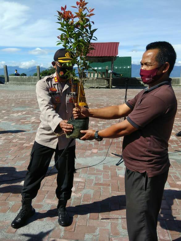Kapolres Bener Meriah AKBP Siswoyo Adi Wijaya S.Ik menyerahkan bibit pohon kepada seorang warga. Rabu, 02/12/2020.